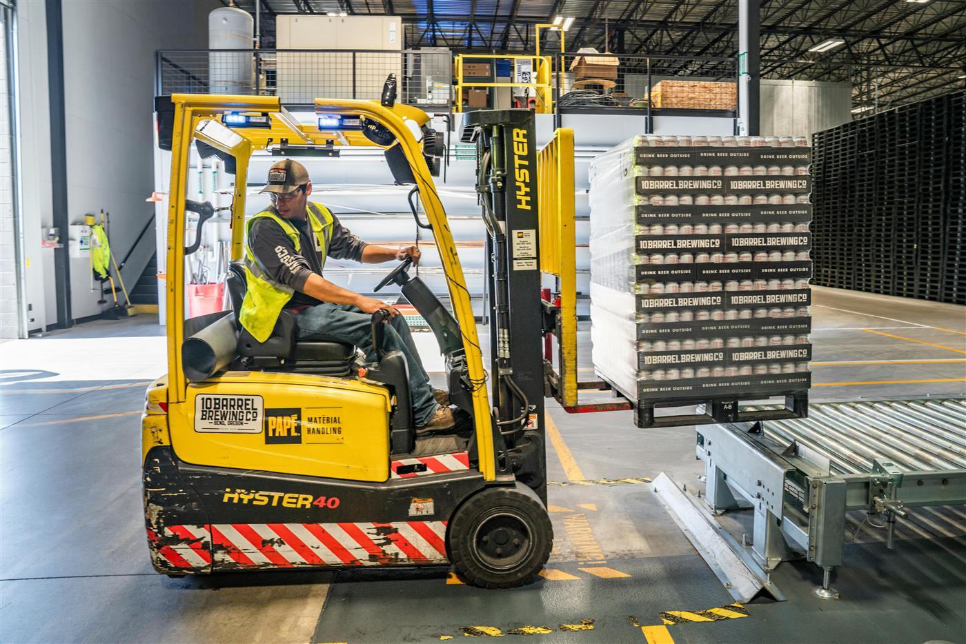 Warehouse cartons on industrial tugs — logistics around packaging lines